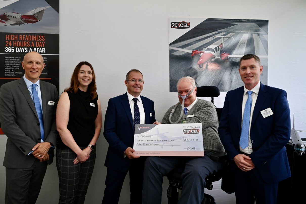 Five people with large charity cheque