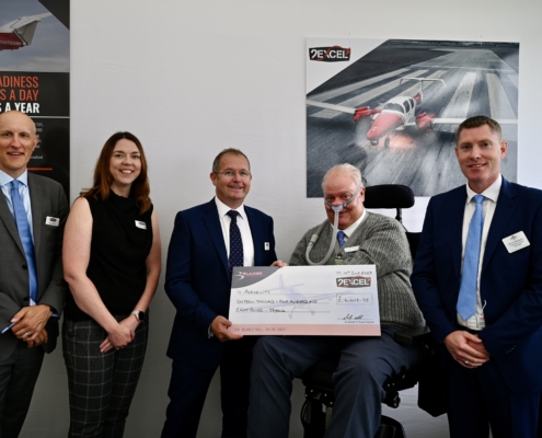 Five people with large charity cheque