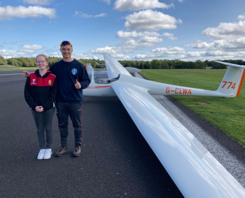 Young man and young woman standing by a glider